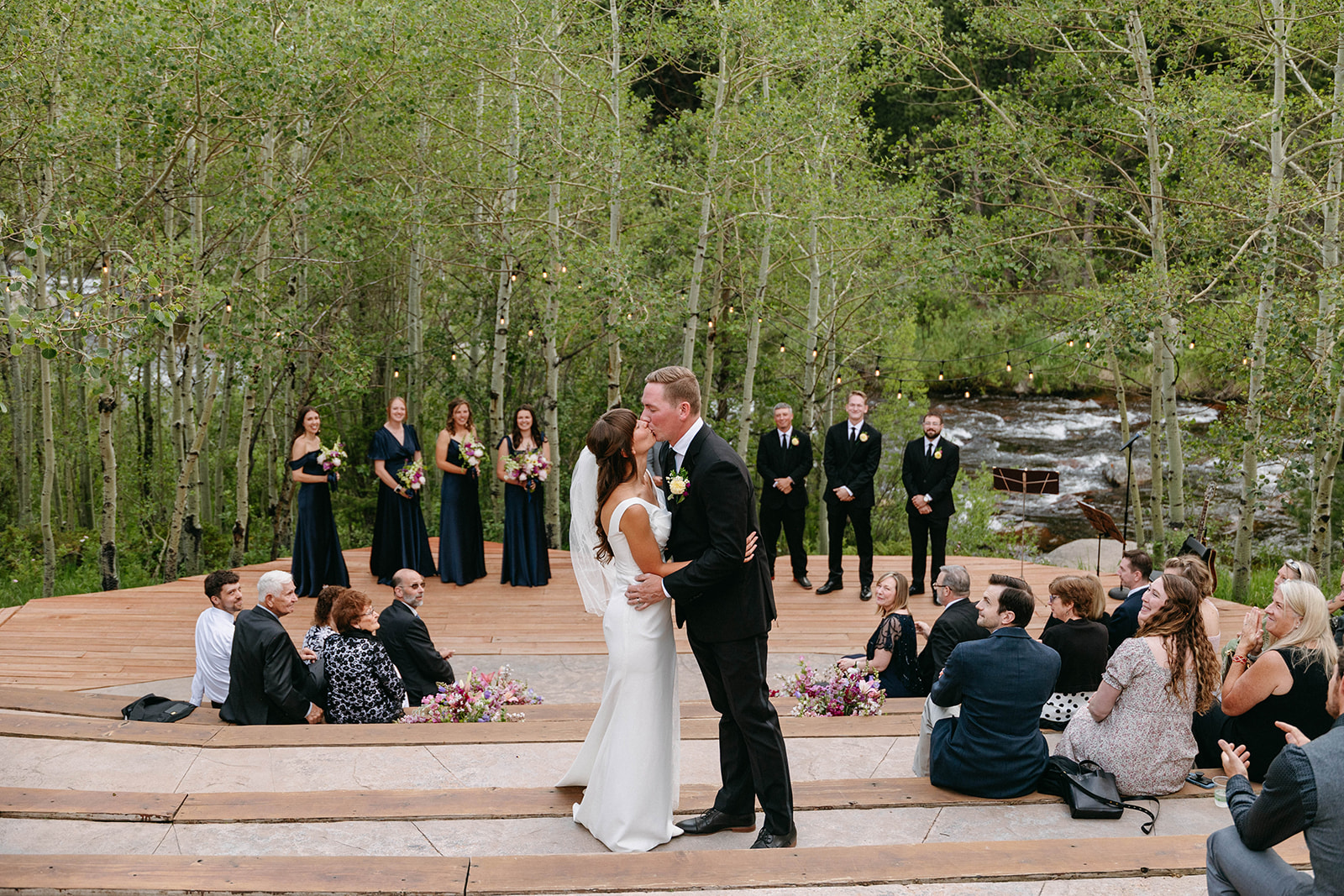 Jason and Amy kissing on the rocks framed by aspen trees
